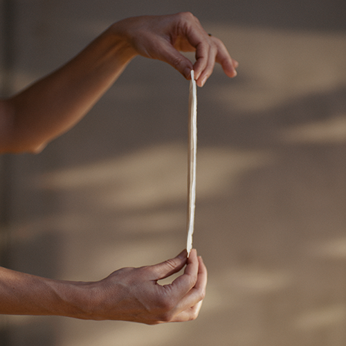 Nahaufnahme einer Frau, die eine TENA Discreet Ultra Slipeinlage für Blasenschwäche hochhält Nahaufnahme einer Frau, die eine TENA Discreet Ultra Slipeinlage für Blasenschwäche hochhält